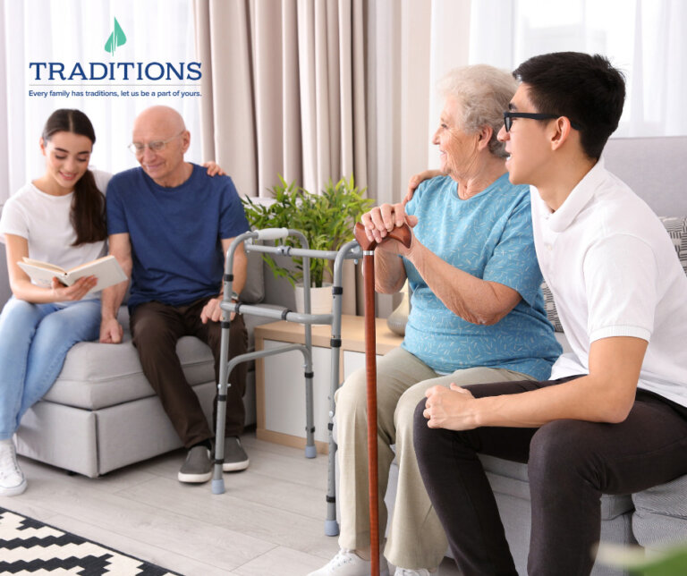 A senior woman sitting on a couch with her grandson while she holds her cane as she looks over at her husband sitting with their grand daughter